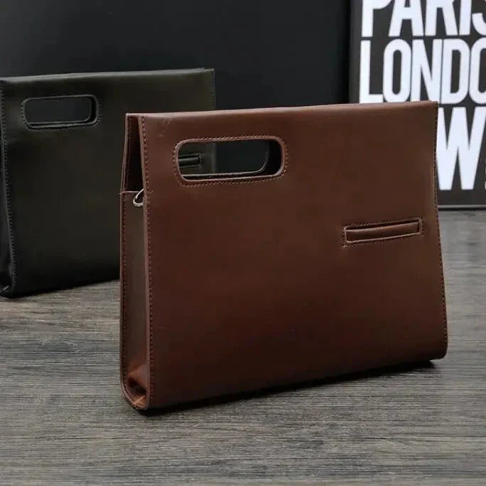 Elegante borsa a mano in pelle marrone su tavolo di legno, design moderno con manico integrato. Sfondo nero con scritta parziale.