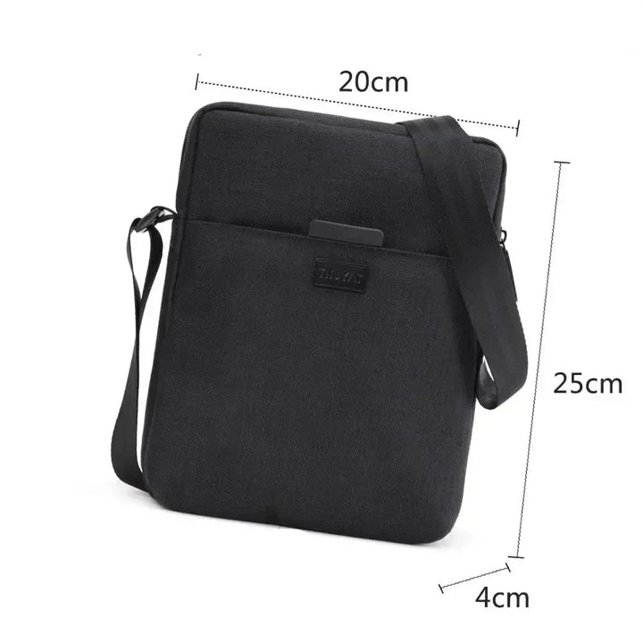 Borsa a tracolla nera in tessuto, dimensioni 20x25x4 cm, con tasca frontale e cinghia regolabile. Ideale per tablet e accessori.