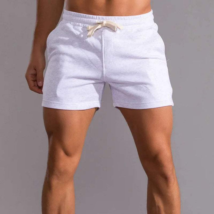 Shorts sportivi da uomo bianchi, tessuto leggero, elastico in vita con laccio, ideali per palestra, fitness e attività all'aperto.