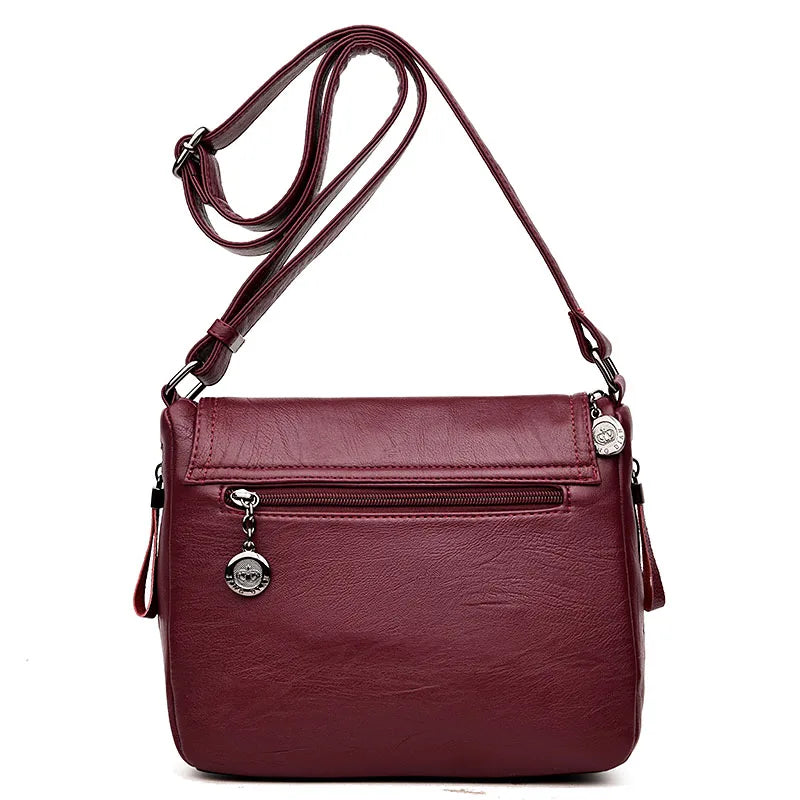 Borsa a tracolla in pelle sintetica bordeaux con cerniera frontale e charm decorativo. Elegante e pratica per uso quotidiano.