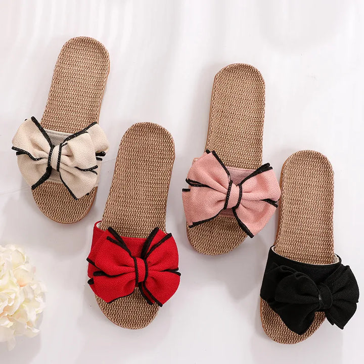 Quattro paia di ciabatte estive in paglia con fiocco colorato: beige, rosa, rosso e nero. Design elegante e comodo per donna.