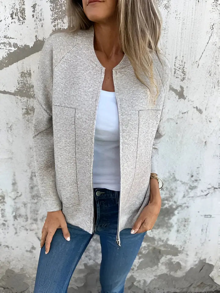 Giacca donna beige chiaro, tessuto morbido, abbinata a jeans blu e top bianco. Moda casual autunnale, stile elegante e confortevole.