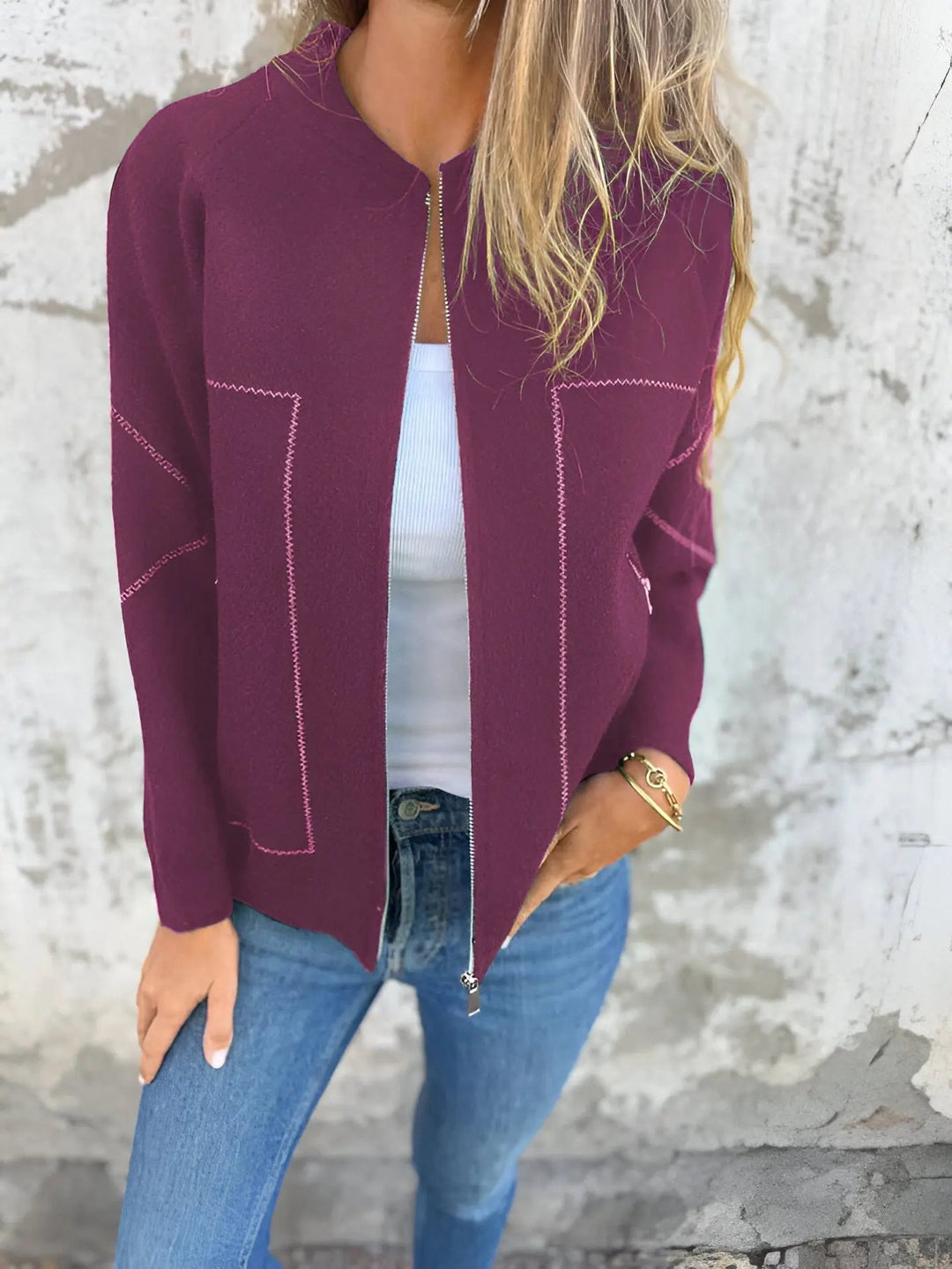 Giacca donna bordeaux aperta, con cuciture a contrasto, indossata su top bianco e jeans. Moda casual autunnale, stile elegante e moderno.