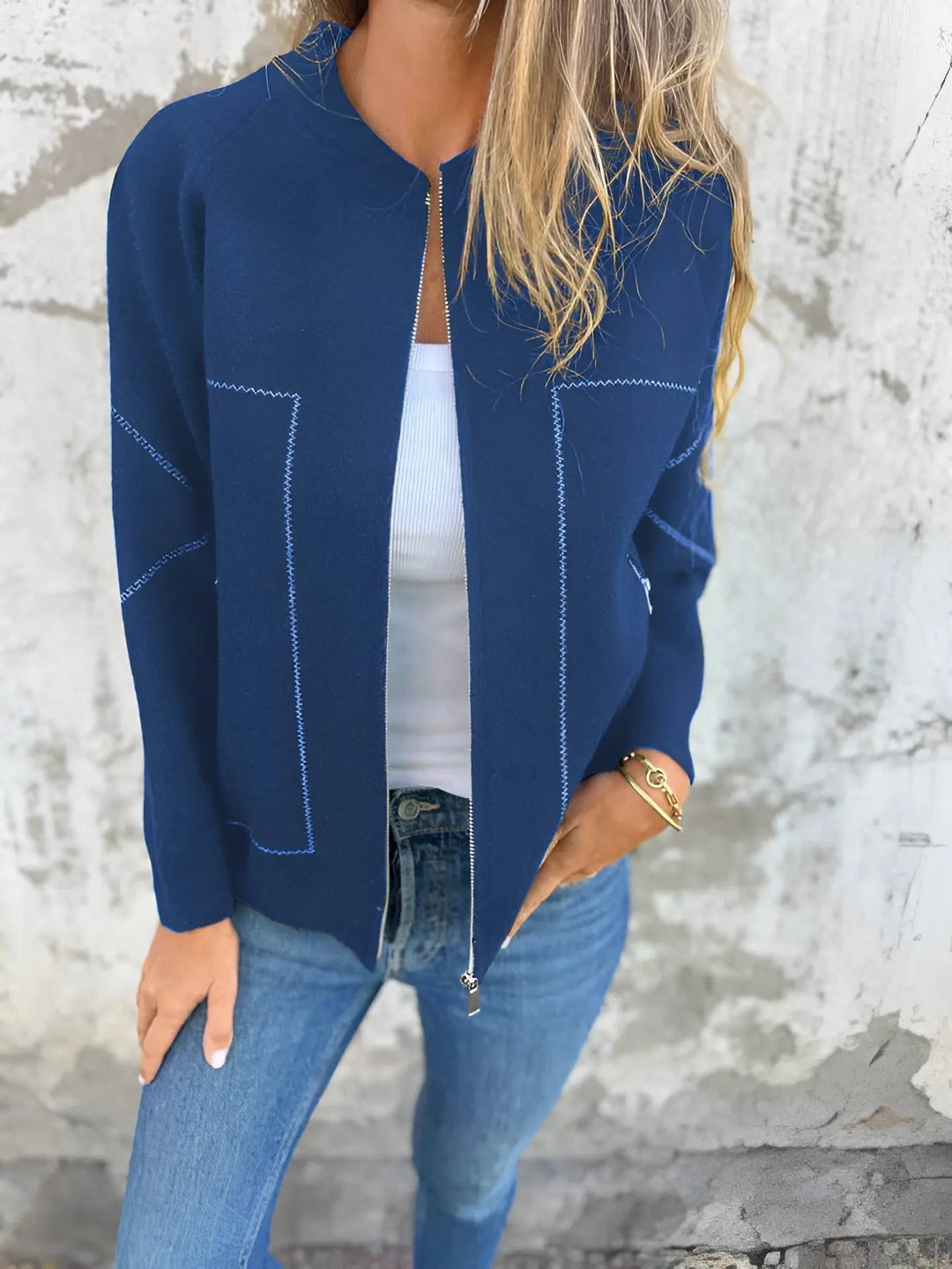 Giacca blu donna, zip frontale, indossata con top bianco e jeans. Moda casual, abbigliamento femminile, stile autunnale.
