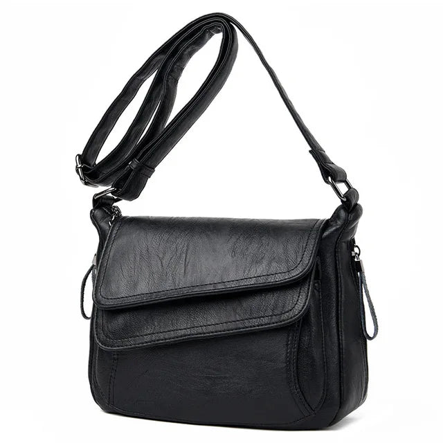 Borsa a tracolla in pelle nera, design elegante e moderno, con chiusura a patta e cerniera, ideale per uso quotidiano e occasioni speciali.