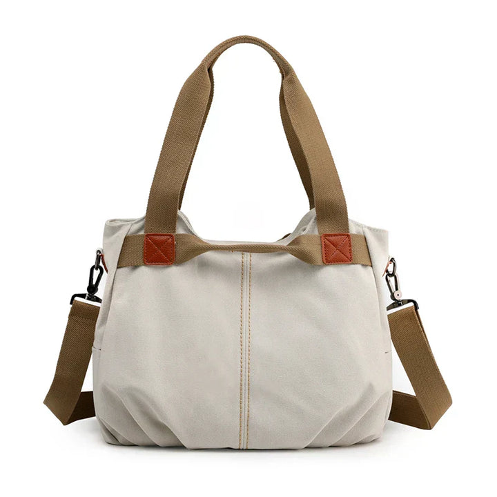 Borsa a tracolla in tela beige con manici marroni, design casual e spazioso, ideale per uso quotidiano. Accessorio moda donna versatile e resistente.