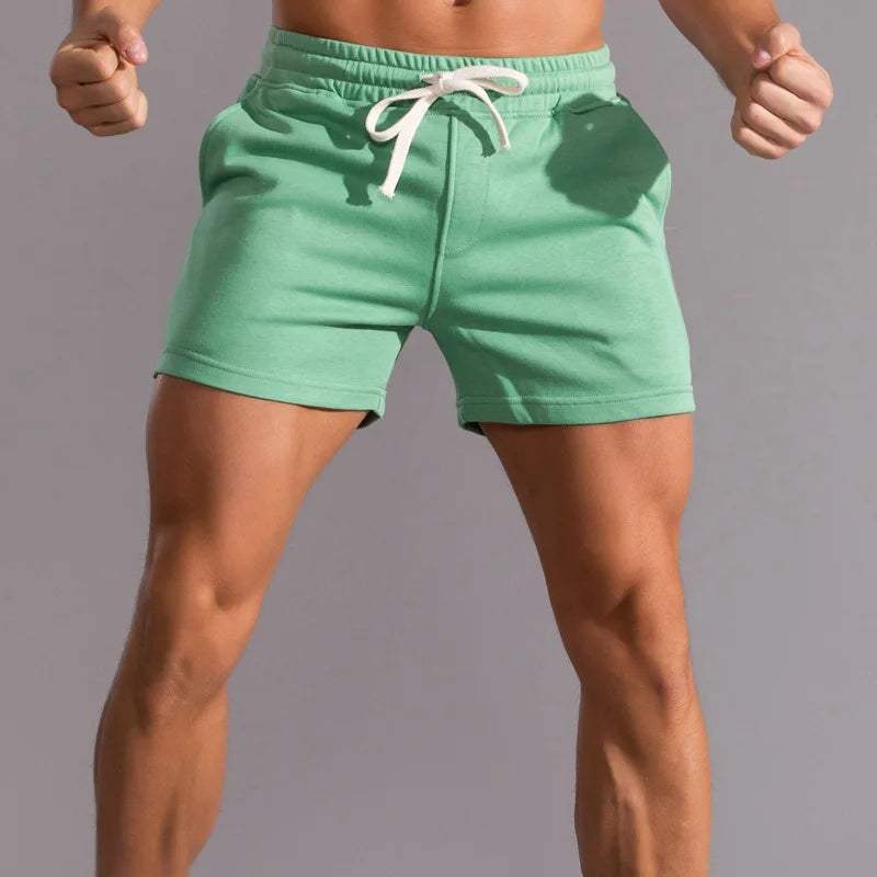 Shorts sportivi verdi da uomo, in cotone, con coulisse bianca. Ideali per palestra, fitness e attività all'aperto. Design comodo e moderno.