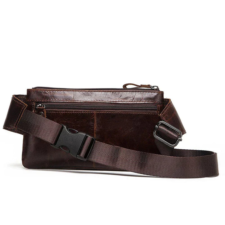 Marsupio in pelle marrone scuro con cerniera, cintura regolabile e fibbia robusta. Accessorio moda uomo, pratico per viaggi e attività all'aperto.