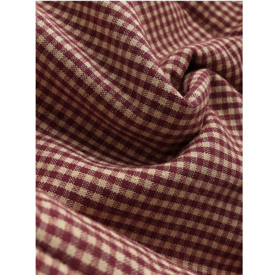 Tessuto a quadretti bordeaux e beige, motivo classico, ideale per abbigliamento e arredamento, texture morbida e resistente.