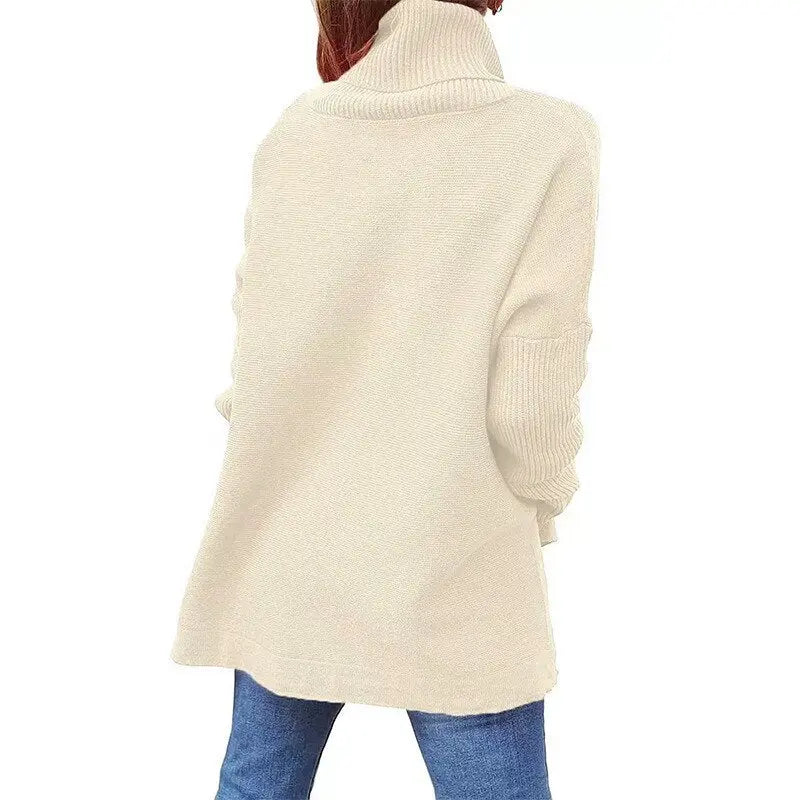 Maglione donna beige a collo alto, maniche lunghe, in maglia morbida, abbinato a jeans blu. Moda autunno inverno, abbigliamento casual elegante.