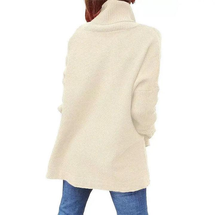Maglione donna beige a collo alto, maniche lunghe, in maglia morbida, abbinato a jeans blu. Moda autunno inverno, abbigliamento casual elegante.