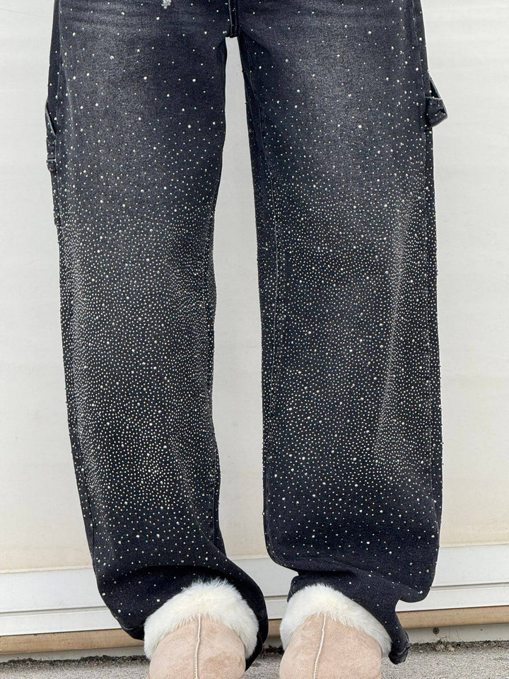 Jeans neri con strass scintillanti, design moderno, vestibilità comoda, abbinati a stivali beige in pelliccia sintetica.