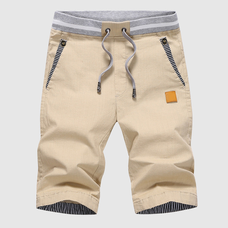 Pantaloncini beige da uomo con coulisse, tasche con zip e dettagli a righe. Ideali per l'estate, moda casual. Disponibili su Google Shopping.
