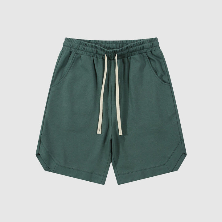 Pantaloncini sportivi verdi da uomo con tasche laterali e coulisse, design casual, tessuto leggero, ideali per attività all'aperto e tempo libero.