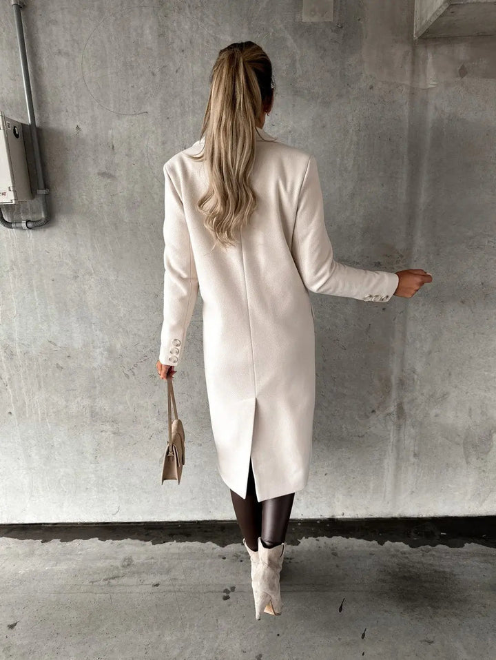 Donna di spalle con cappotto bianco elegante, stivali beige e borsa a mano. Moda autunnale, stile sofisticato, abbigliamento femminile di tendenza.