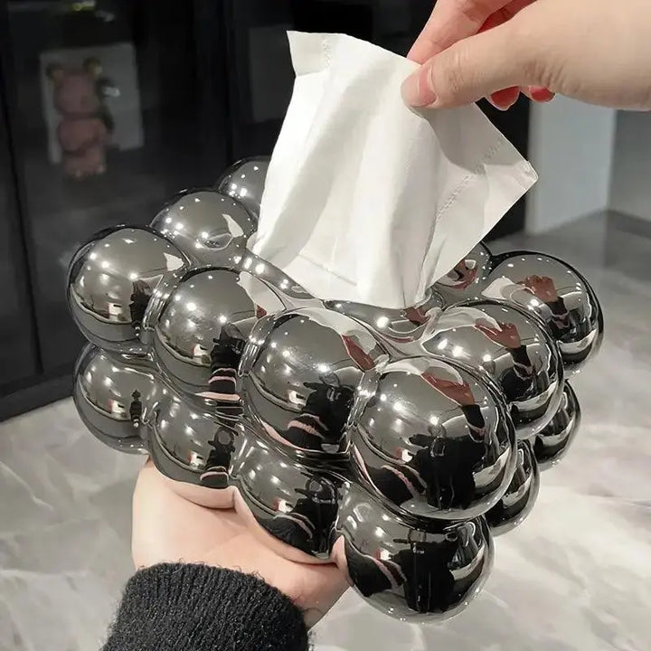 Porta fazzoletti moderno in metallo cromato, design a bolle, tenuto in mano. Accessorio elegante per casa, bagno o ufficio.