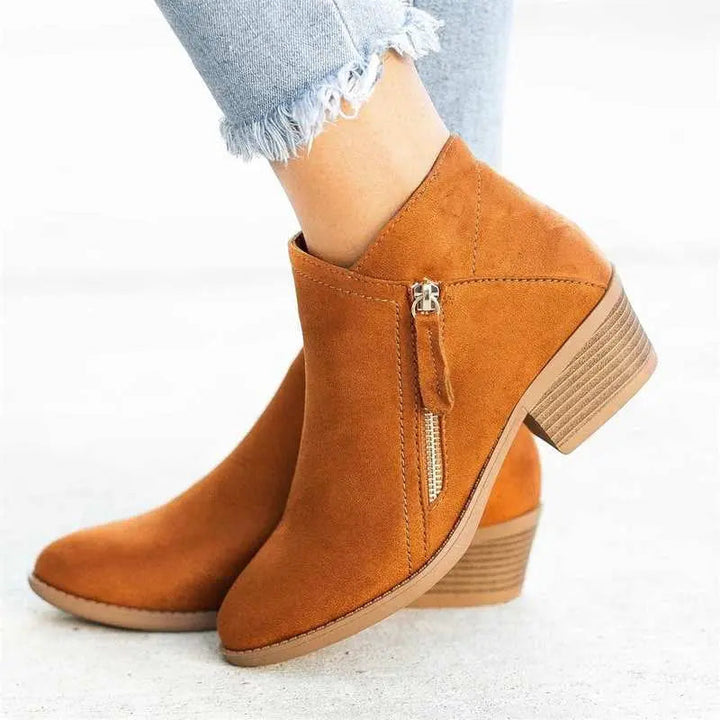 Stivaletti donna in camoscio marrone con tacco basso, zip laterale, indossati con jeans chiari. Scarpe moda autunno inverno eleganti e casual.