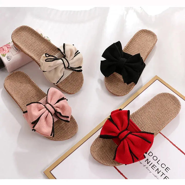 Quattro paia di ciabatte estive in paglia con fiocco colorato: beige, nero, rosa e rosso. Design elegante, perfette per la moda estiva.