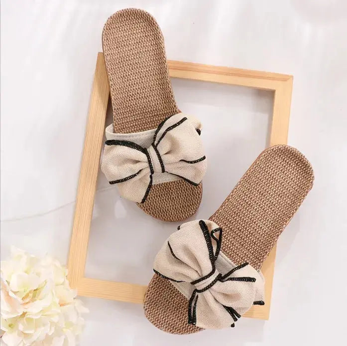 Sandali estivi da donna in paglia con fiocco decorativo, colore beige, su sfondo bianco. Scarpe casual eleganti, ideali per la moda estiva.