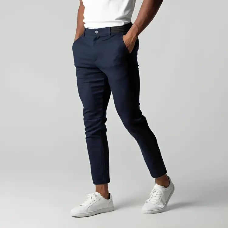 Pantaloni chino blu scuro da uomo, eleganti e moderni, abbinati a scarpe da ginnastica bianche. Ideali per look casual e formali.