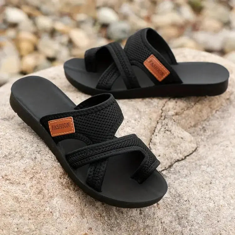 Sandali neri da uomo su roccia, design intrecciato, suola antiscivolo, etichetta marrone "Fashion", ideali per estate e casual.