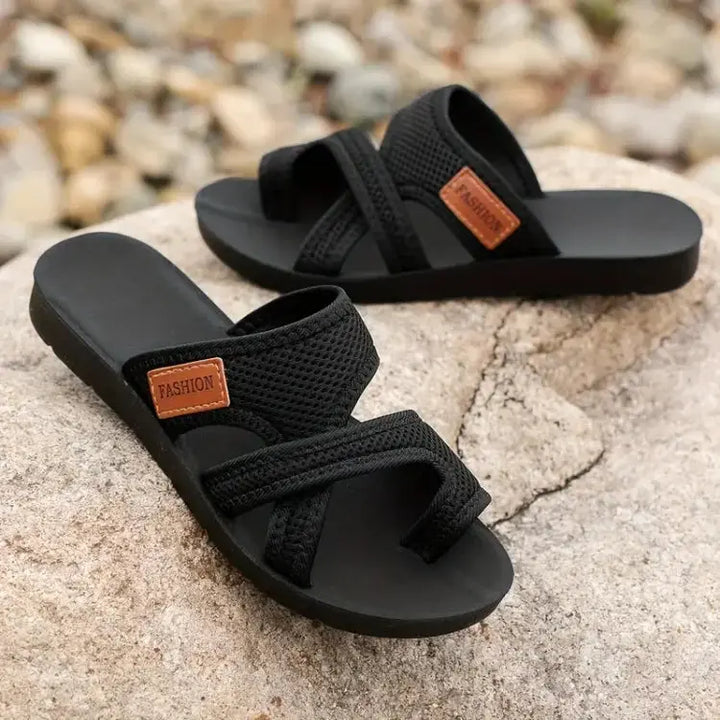 Sandali neri da uomo su roccia, design intrecciato, suola antiscivolo, etichetta marrone "Fashion", ideali per estate e casual.