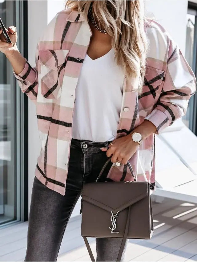 Donna con camicia a quadri rosa, t-shirt bianca, jeans neri, borsa a mano grigia e orologio dorato. Moda casual chic, accessori eleganti.