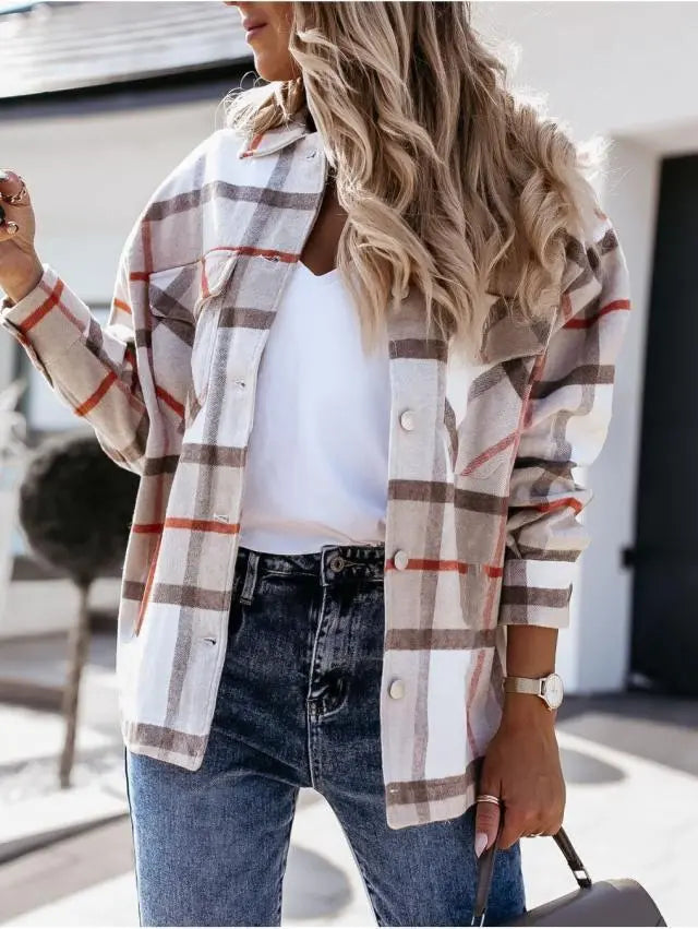 Donna con camicia a quadri beige e rossi, t-shirt bianca, jeans blu. Moda autunnale casual, look trendy, outfit femminile elegante.