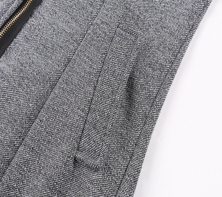 Giacca in tessuto grigio a spina di pesce con cerniera nera e tasca laterale. Elegante e moderna, ideale per abbigliamento formale e casual.