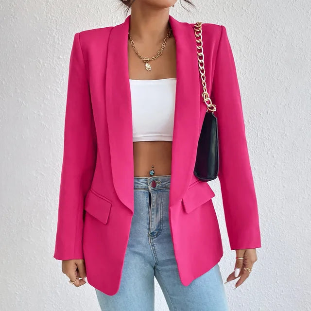 Giacca blazer donna fucsia elegante, abbinata a top bianco e jeans, con borsa a catena nera. Moda femminile, abbigliamento casual chic.