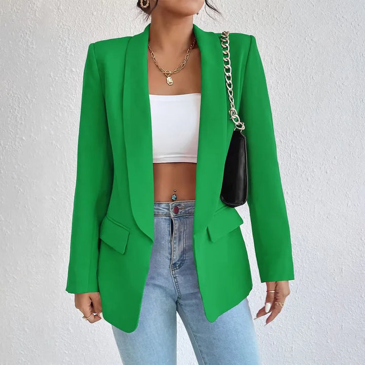 Giacca verde elegante da donna, abbinata a top bianco e jeans. Moda femminile, abbigliamento casual chic, blazer moderno per look trendy.