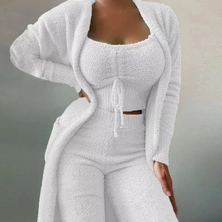 Set coordinato donna in maglia bianca, composto da cardigan lungo, top corto e pantaloni a vita alta. Abbigliamento moda femminile elegante e confortevole.