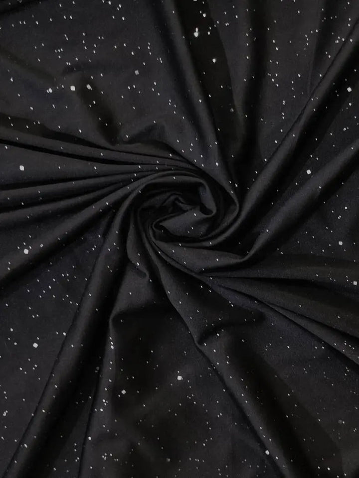 Tessuto nero con motivo a stelle bianche, ideale per abbigliamento e decorazioni. Materiale morbido e resistente, perfetto per progetti creativi.