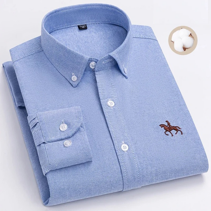 Camicia uomo azzurra in cotone, maniche lunghe, colletto button-down, ricamo cavallo, elegante e casual, ideale per ufficio e tempo libero.