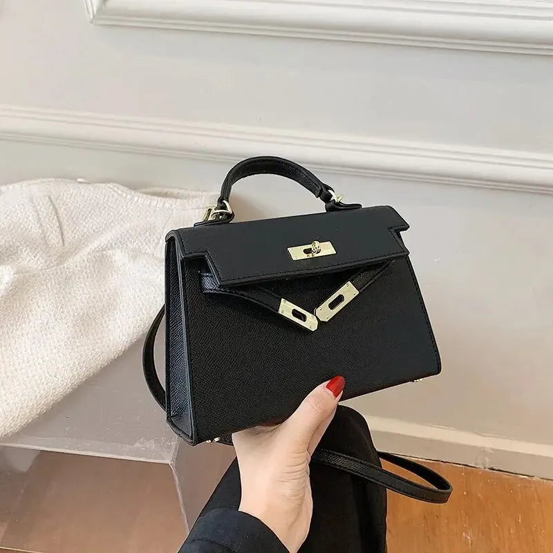 Borsa a mano nera elegante in pelle, design classico, chiusura a girello dorata, manico superiore, perfetta per moda donna e accessori di lusso.