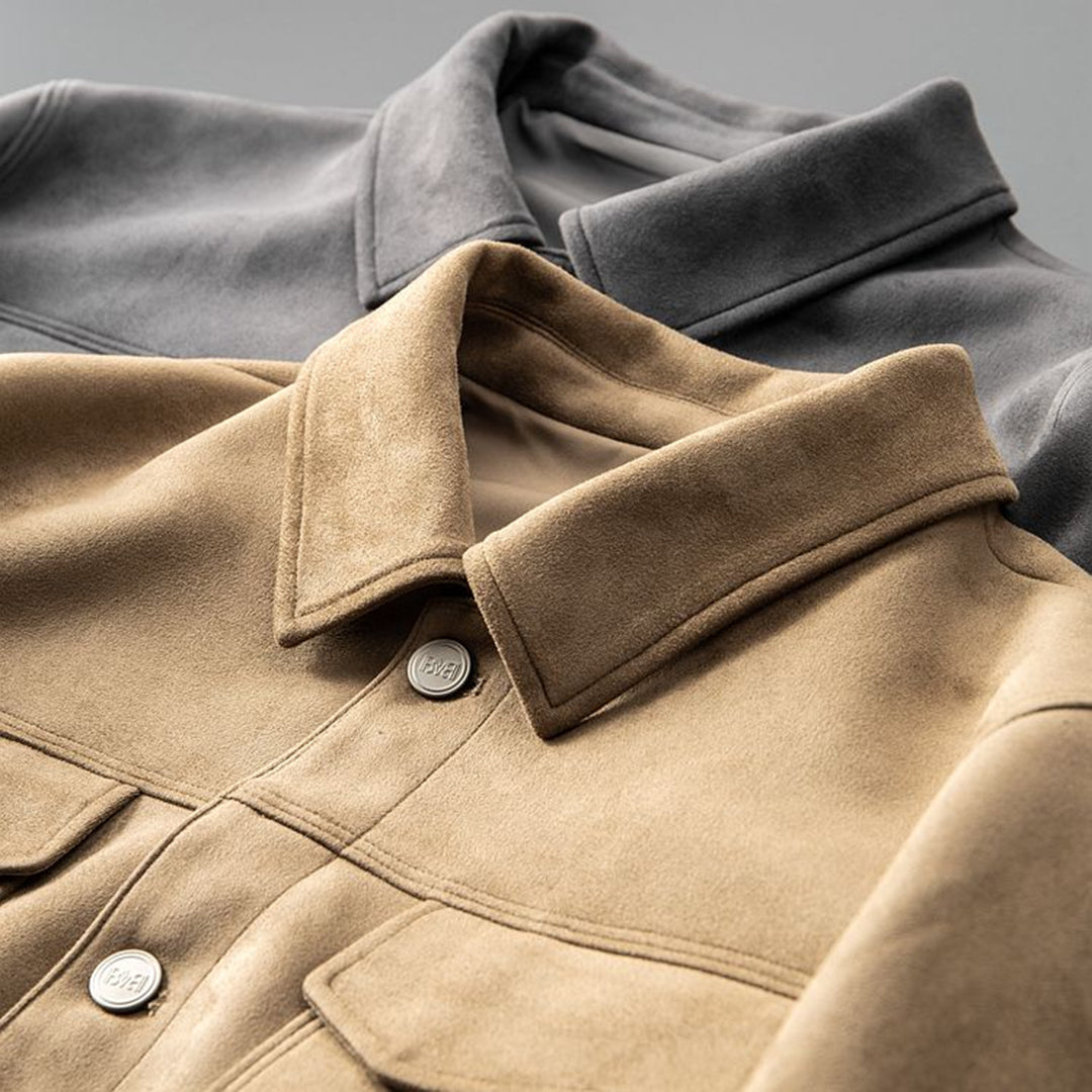 Due giacche di pelle scamosciata, una beige e una grigia, con colletto classico e bottoni metallici, su sfondo grigio. Moda autunnale elegante.