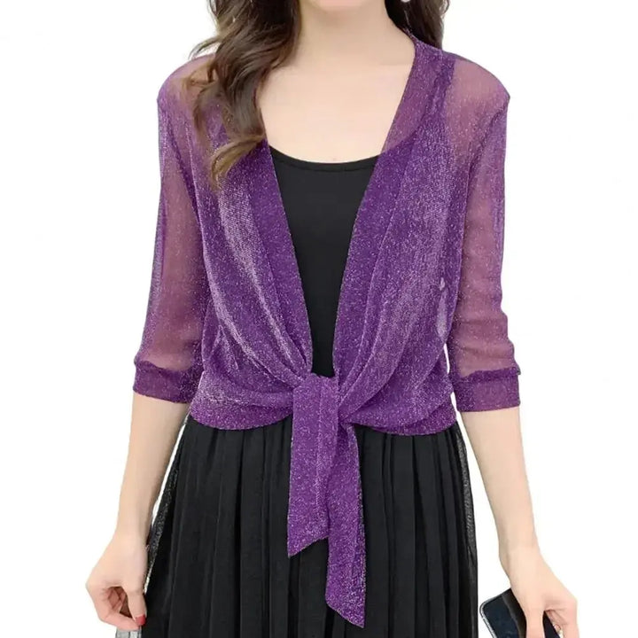 Donna con cardigan viola trasparente a maniche tre quarti, annodato sul davanti, sopra un abito nero. Moda elegante, abbigliamento femminile.