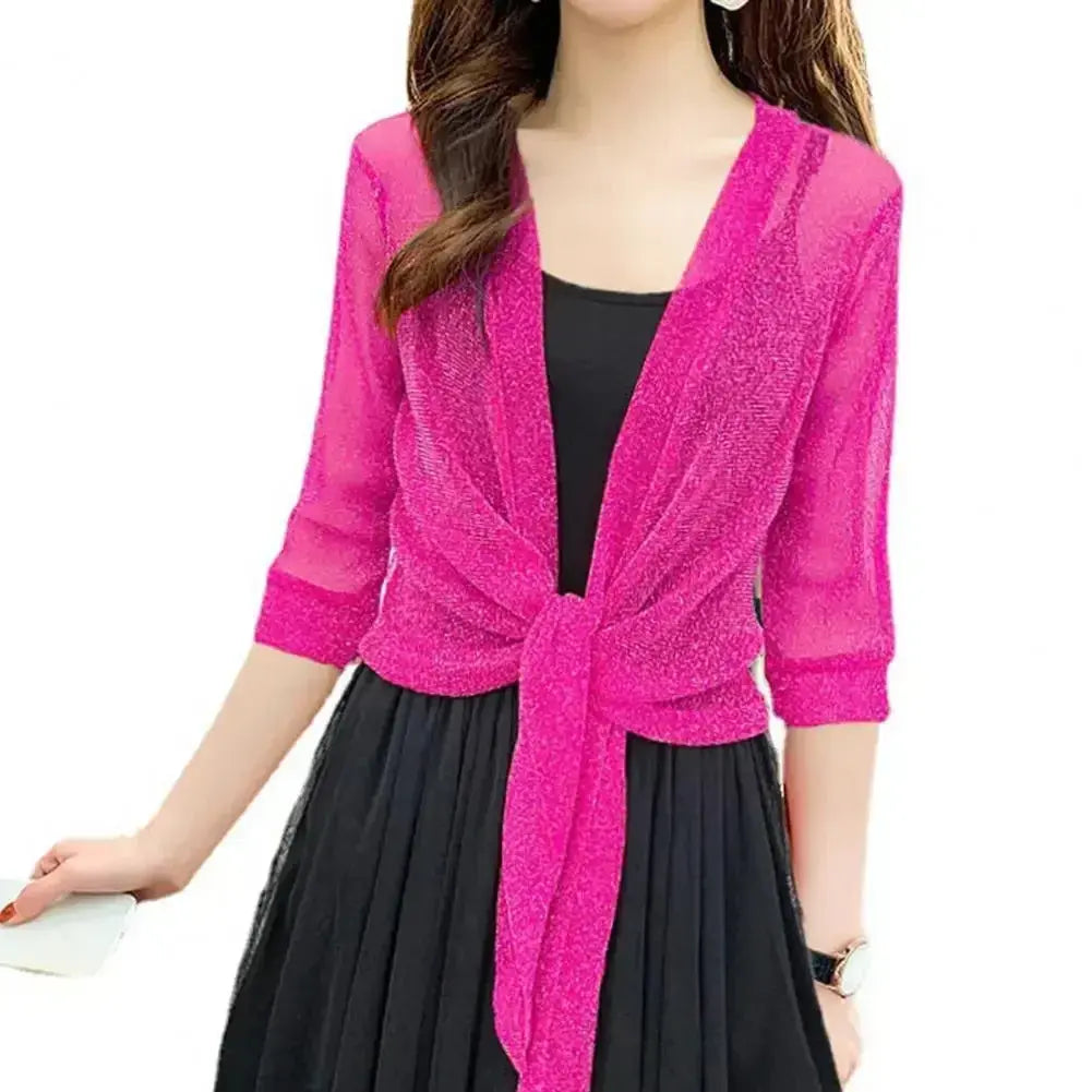 Cardigan donna rosa trasparente, maniche a tre quarti, annodato sul davanti, sopra abito nero. Moda femminile elegante, abbigliamento estivo.