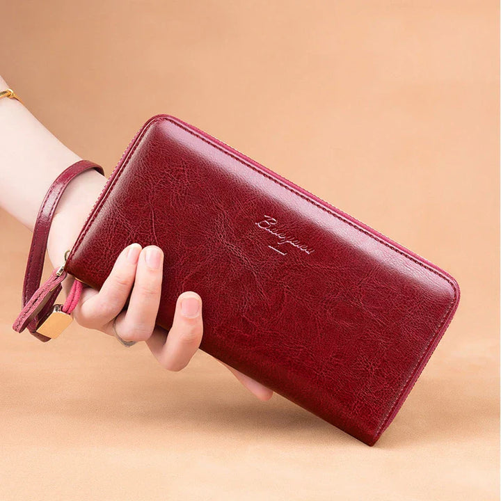 Portafoglio donna in pelle rossa, design elegante con cerniera, cinturino da polso, ideale per moda e accessori femminili.