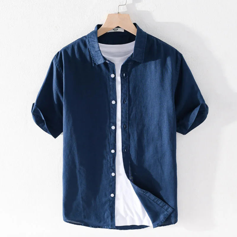 Camicia uomo blu scuro a maniche corte, in cotone, con bottoni bianchi, su gruccia. Stile casual, perfetta per l'estate.