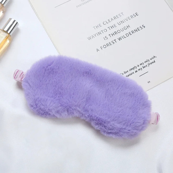 Mascherina per dormire in pelliccia sintetica viola, morbida e confortevole, su sfondo bianco. Accessorio relax, ideale per il sonno e il riposo.