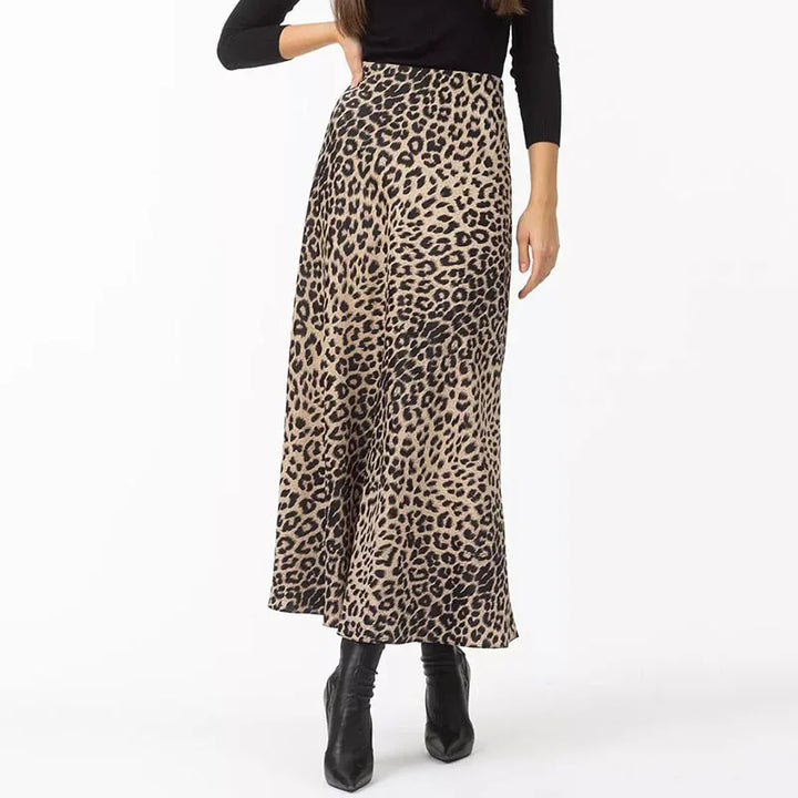 Gonna lunga leopardata donna, elegante e alla moda, abbinata a stivali neri e maglia nera. Stile casual chic, perfetta per ogni occasione.