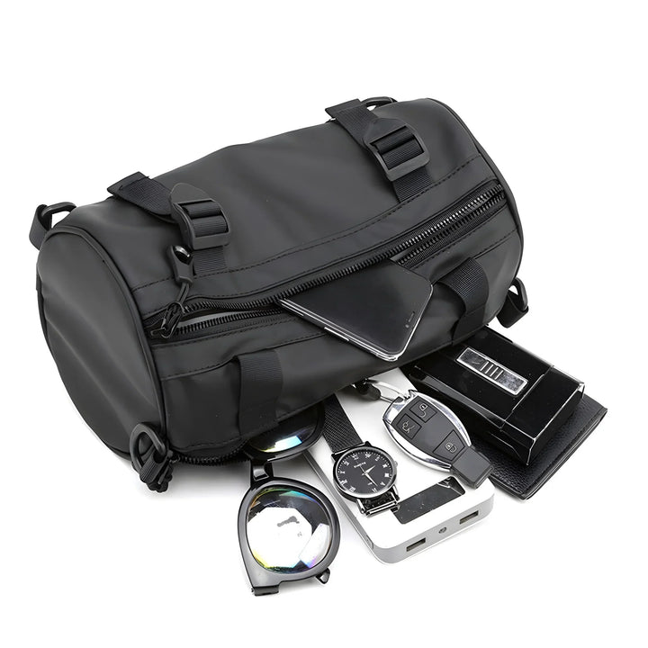 Borsa a tracolla cilindrica nera impermeabile con smartphone, occhiali da sole, orologio, chiavi auto e power bank. Accessori moda uomo.