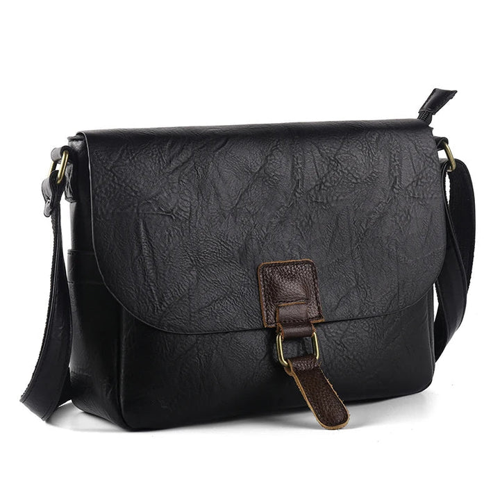Borsa a tracolla in pelle nera con fibbia marrone, design elegante e spazioso, ideale per uomo e donna. Accessorio moda versatile e resistente.