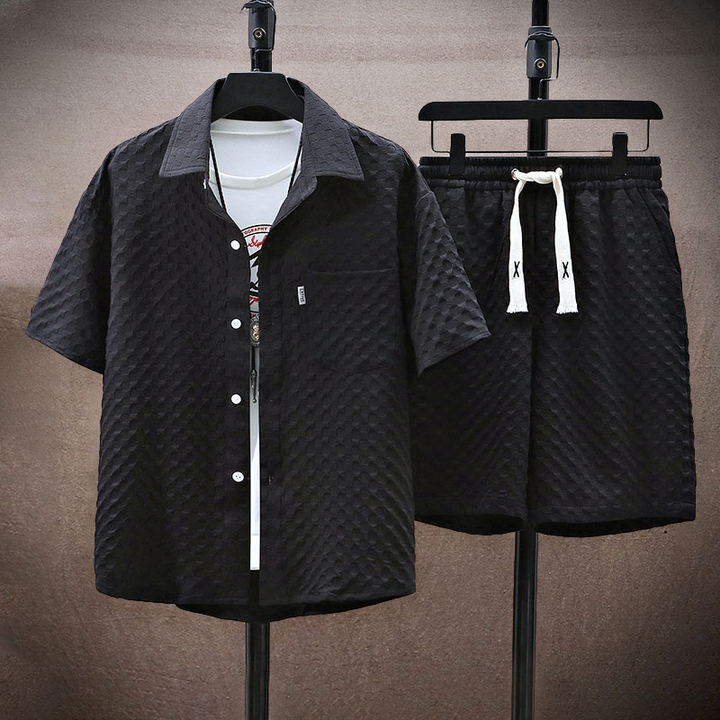 Set coordinato estivo uomo, camicia e pantaloncini neri con texture, t-shirt bianca sottostante, stile casual, moda maschile, abbigliamento leggero.