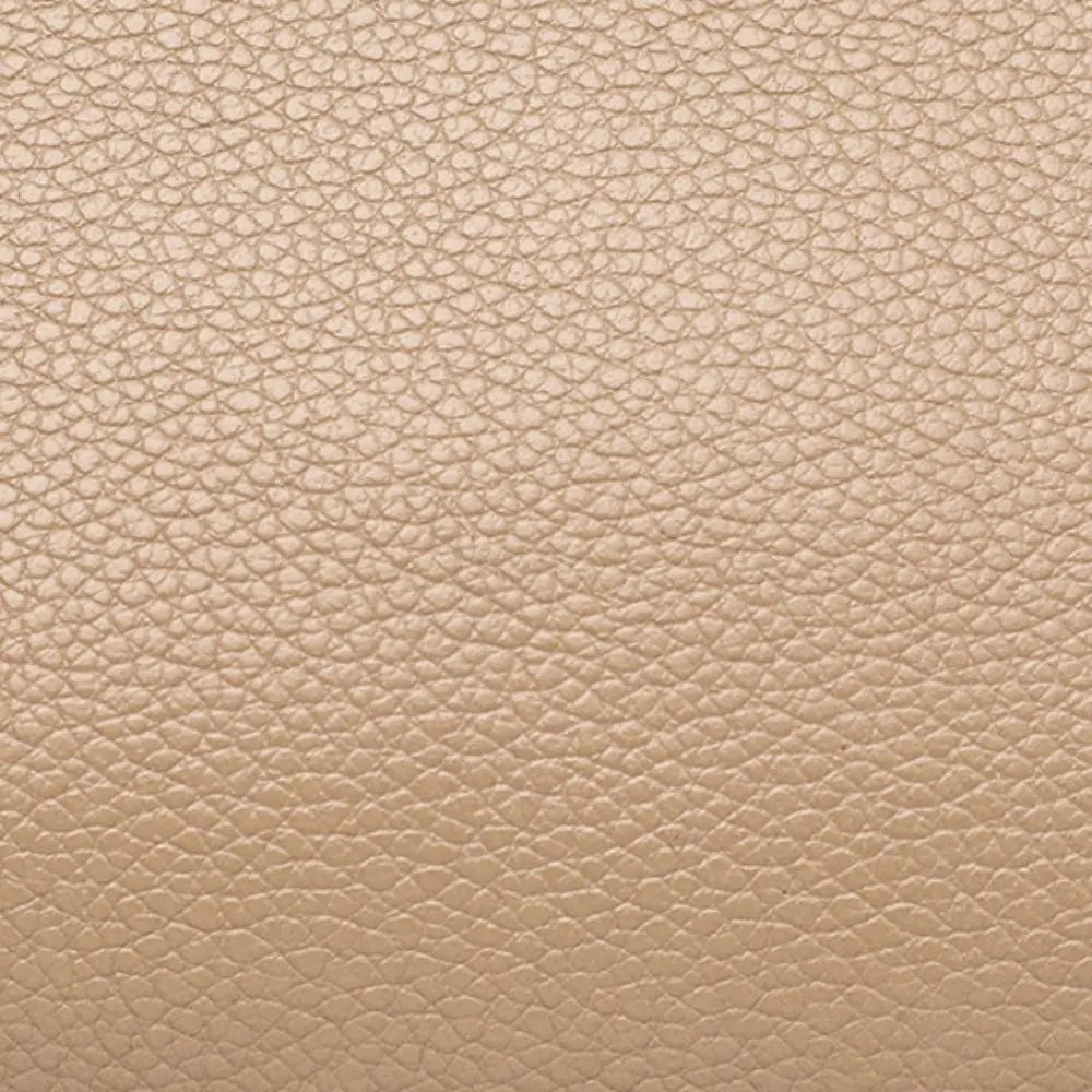 Texture in pelle beige chiaro, superficie granulosa, ideale per design di moda e arredamento. Materiale elegante e versatile per accessori di lusso.