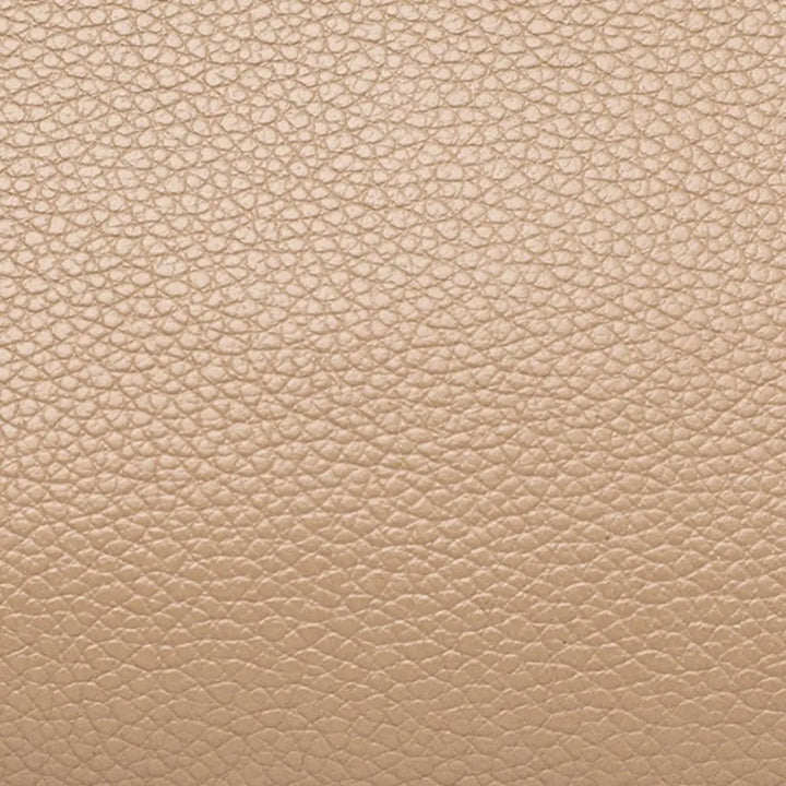 Texture in pelle beige chiaro, superficie granulosa, ideale per design di moda e arredamento. Materiale elegante e versatile per accessori di lusso.