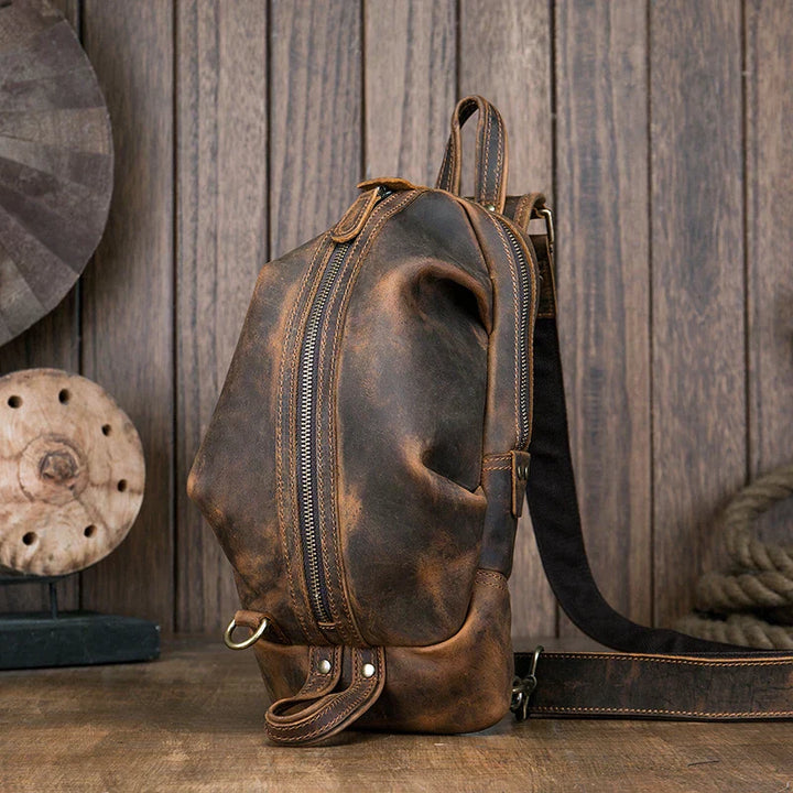 Zaino in pelle vintage marrone su sfondo di legno, design elegante e resistente, ideale per viaggi e uso quotidiano. Accessorio moda uomo.