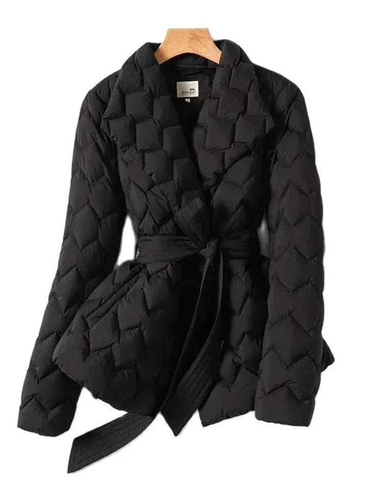 Giacca trapuntata nera da donna con cintura, design elegante e moderno, ideale per l'inverno. Tessuto caldo e confortevole, perfetto per look casual.