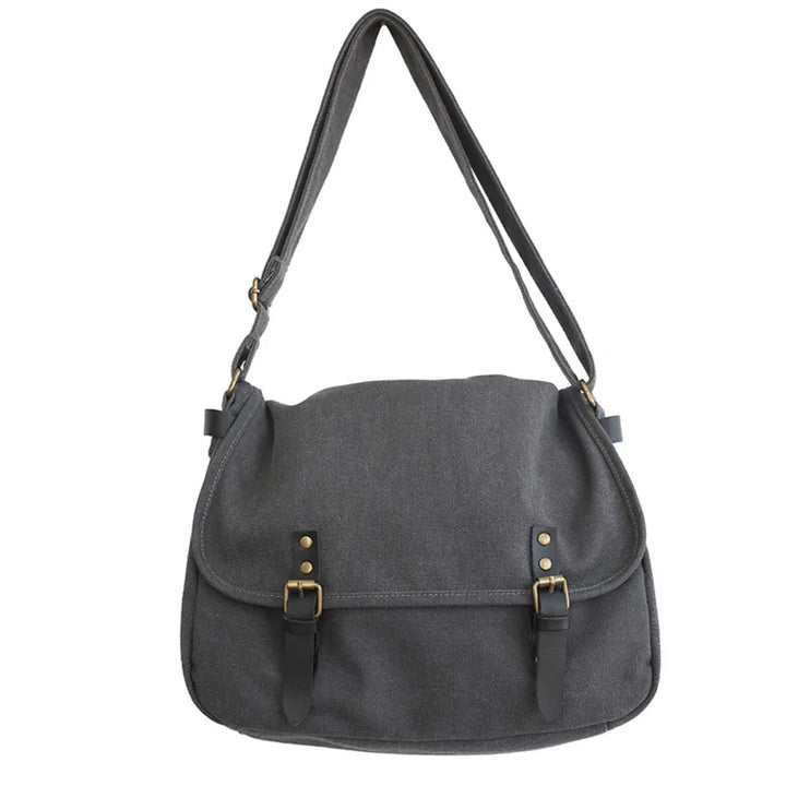 Borsa a tracolla in tela grigia con fibbie in pelle nera, design casual e spazioso, ideale per uso quotidiano e viaggi.
